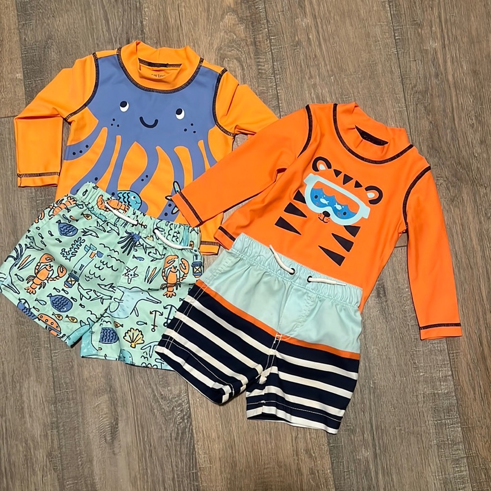 Two Carter’s swim trunks and rash guards